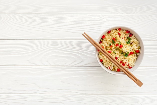 Foto macarrão instantâneo asiático tradicional em um prato com pauzinhos