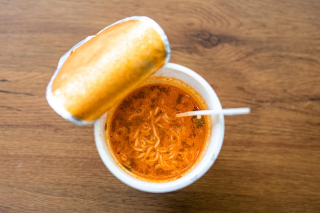 Macarrão instantâneo preparado em um copo de plástico na mesa