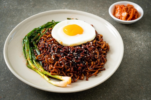 Macarrão instantâneo seco caseiro com molho preto picante coreano com ovo frito e kimchi