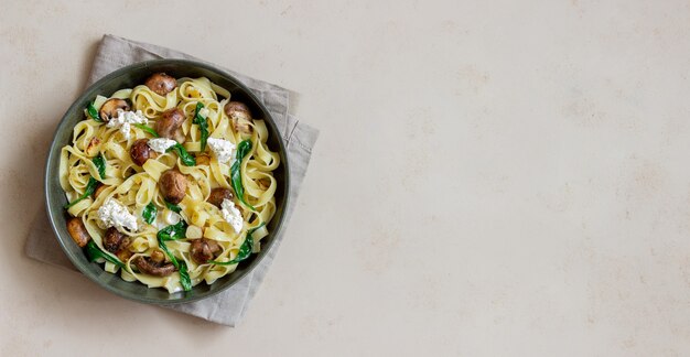 Macarrão linguine com cogumelos, queijo branco, espinafre e alho. Alimentação saudável. Comida vegetariana. Dieta.