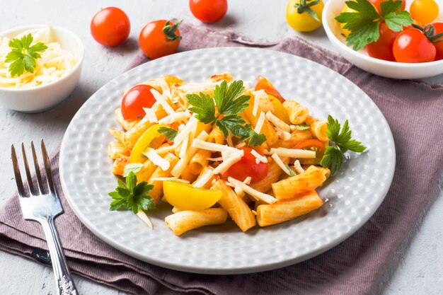 Macarrão, macarrão em molho de tomate e queijo em um prato sobre uma mesa de madeira