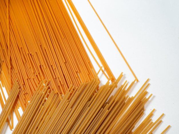 Macarrão na mesa Espaguete de dois tipos em um fundo branco Macarrão de tomate e trigo sarraceno Comida italiana Cozinha dos povos do mundo Cozinhar alimentos