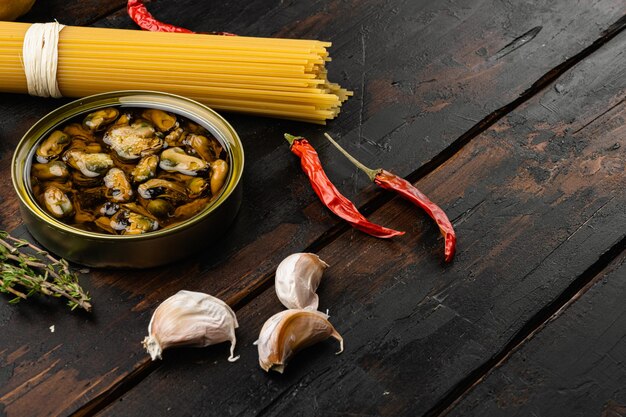 Macarrão não cozido espaguete alle vongole conjunto de ingredientes de massas de frutos do mar, sobre fundo de mesa de madeira escura velha, com espaço de cópia para texto