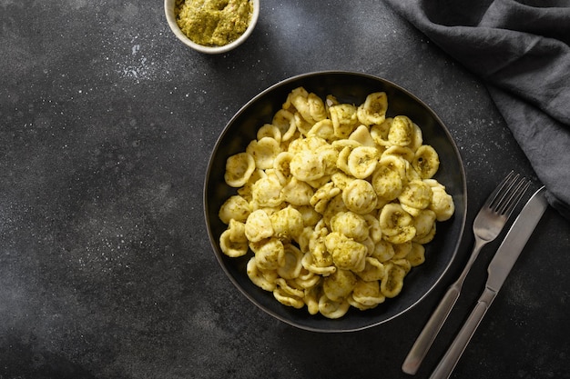 Macarrão Orecchiette com molho pesto em fundo preto