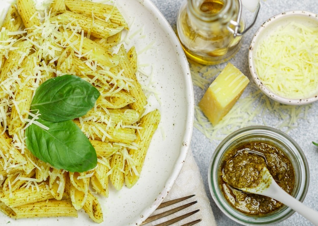 Macarrão penne com molho pesto, queijo parmesão, azeite e manjericão