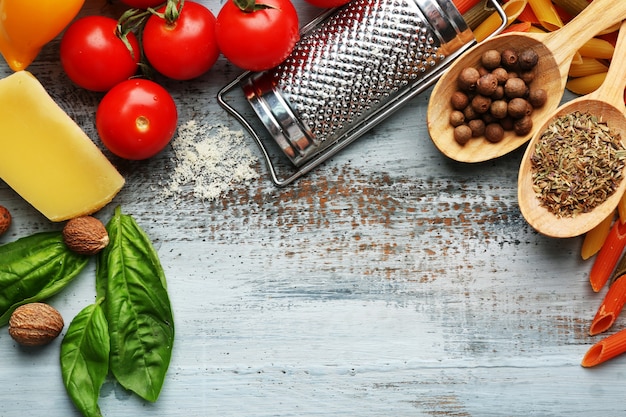 Macarrão penne com tomate, queijo e manjericão na parede de madeira colorida