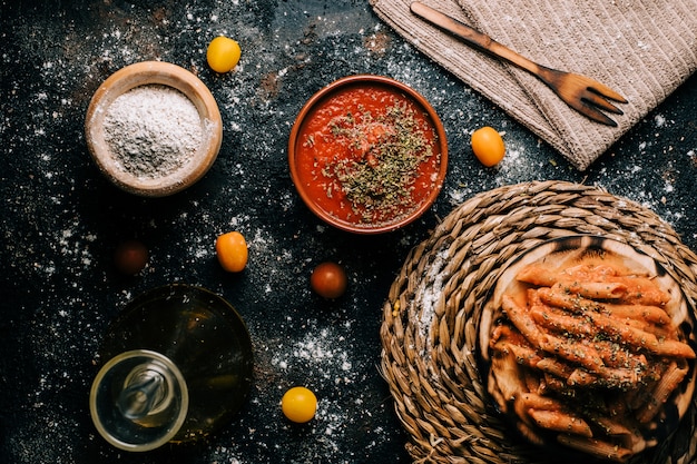 Macarrão Penne. Macarrão integral caseiro com molho de tomate na mesa de madeira velha