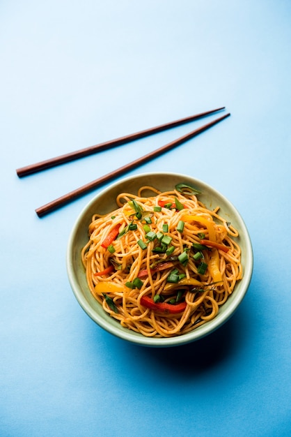 Macarrão Schezwan ou macarrão Hakka de vegetais ou chow mein são receitas indo-chinesas populares, servidas em uma tigela ou prato com pauzinhos de madeira