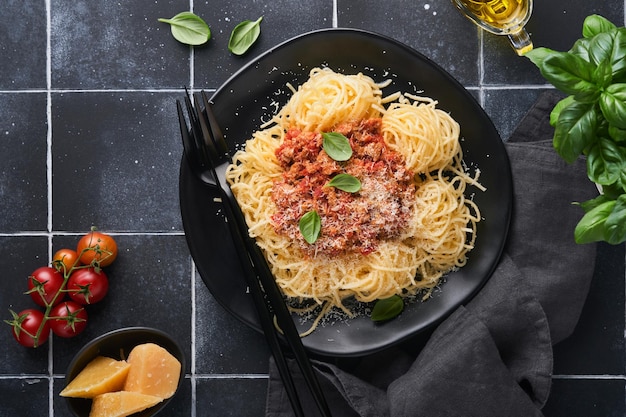 Macarrão tagliatelle com almôndegas em molho de tomate manjericão e queijo parmesão em pedra preta ou fundo de concreto prato tradicional italiano e cozinha vista superior com espaço de cópia