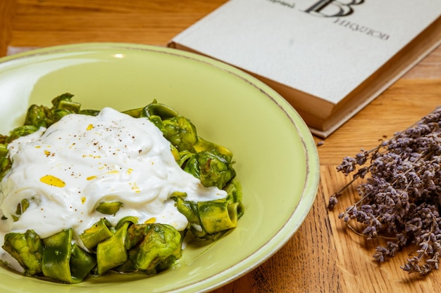 Macarrão Tagliatelle com foco seletivo de pesto de espinafre e ervilha verde