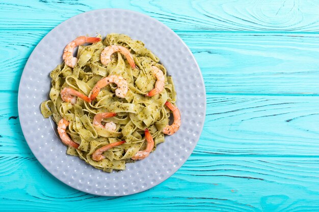 Macarrão tagliatelle com molho pesto e camarão fundo de comida italiana