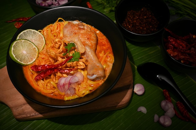 Macarrão tailandês do norte com coxa de frango e legumes na mesa Khao Soi Kai