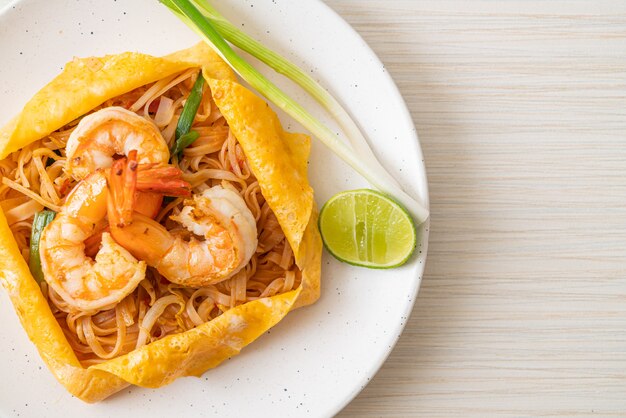 Macarrão tailandês frito com camarão e embrulho de ovo (Pad Thai), comida tailandesa