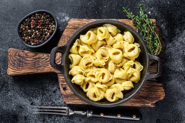 Macarrão tortellini italiano com molho de queijo em uma panela.