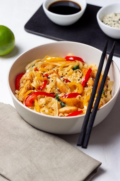 Macarrão Udon com frango, pimenta e gergelim. Comida chinesa.