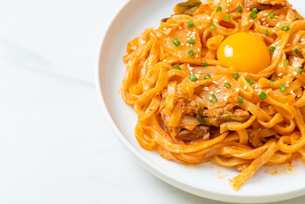 macarrão udon frito com kimchi e carne de porco - estilo de comida coreana