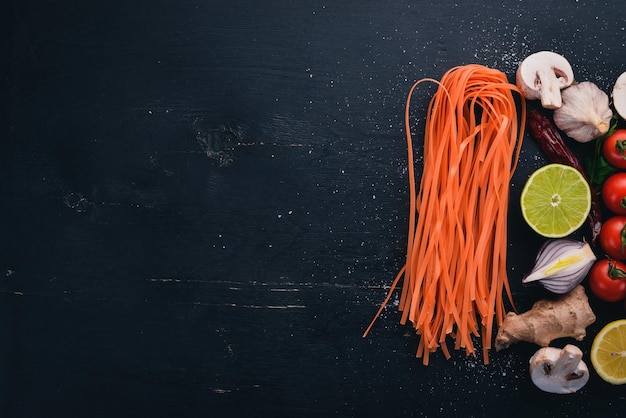 Macarrão vermelho com tomates cozinha tradicional italiana em um fundo de madeira vista superior Copiar espaço