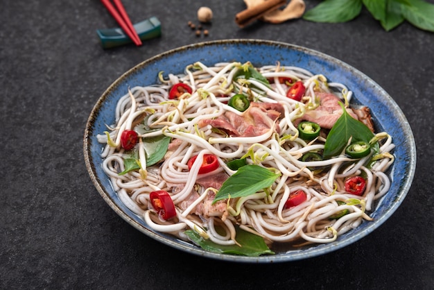 macarrão vietnamita de carne e vegetais com fundo de pauzinho