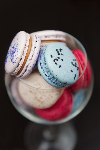 Macarrones azules y rosados en un vaso.