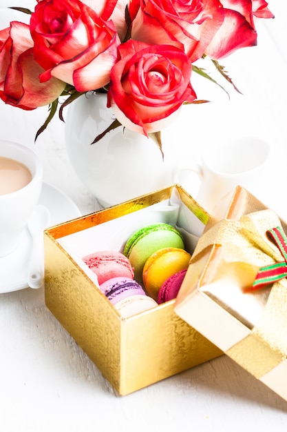 Macarrones en caja de regalo y rosas en florero