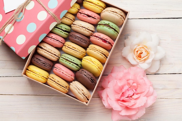 Macarrones de colores en una caja de regalo y rosas