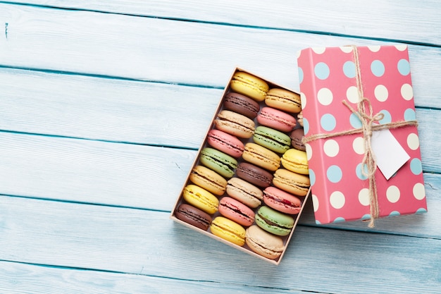 Foto macarrones de colores en una caja de regalo