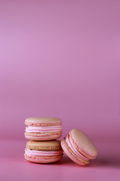 macarrones con crema de mantequilla rosa sobre fondo rosa