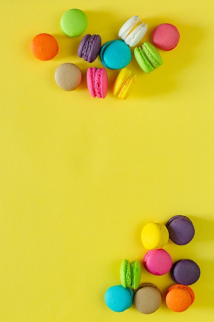 Macarrones franceses dulces y coloridos o macarrones sobre fondo amarillo Postre comer con té