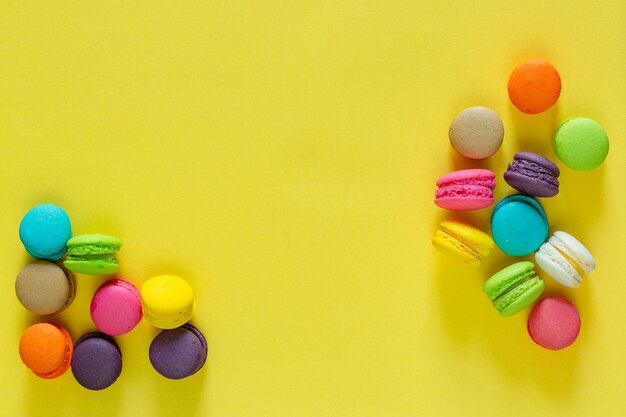 Macarrones franceses dulces y coloridos o macarrones sobre fondo amarillo Postre comer con té