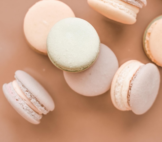 Macarrones franceses sobre fondo beige crema postre de café elegante parisino comida dulce y pastel macaron para diseño de fondo de vacaciones de marca de confitería de lujo