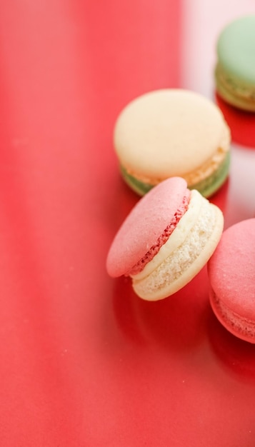 Macarrones franceses sobre fondo rojo parisino elegante café postre comida dulce y pastel macaron para diseño de fondo de vacaciones de marca de confitería de lujo