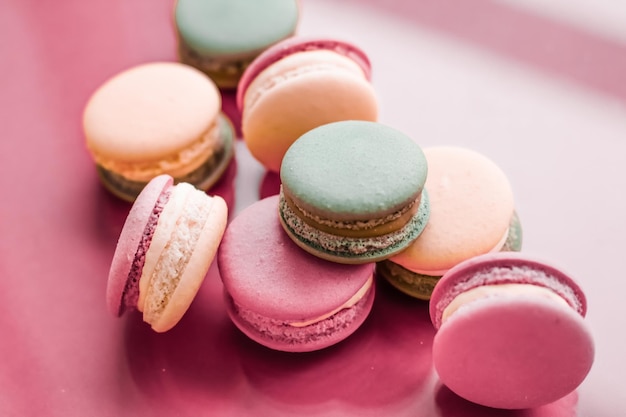 Macarrones franceses sobre fondo rosa pastel postre de café elegante parisino comida dulce y pastel macaron para diseño de fondo de vacaciones de marca de confitería de lujo