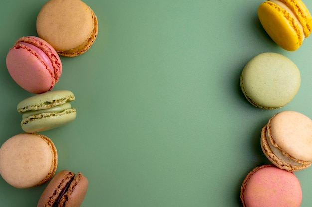 Macarrones galletas coloridas Macarons en un tazón postre dulce francés vista superior fondo verde Copiar espacio