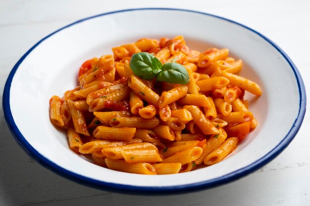 Foto macarrones italianos con salsa de tomate y albahaca