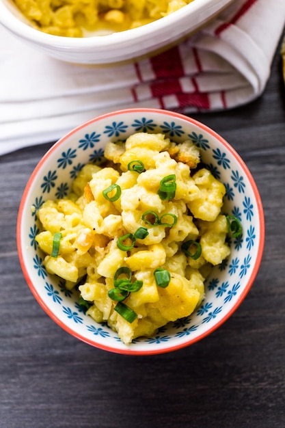 Macarrones con queso al horno con rumbos de cuentas y aderezado con cebollino.