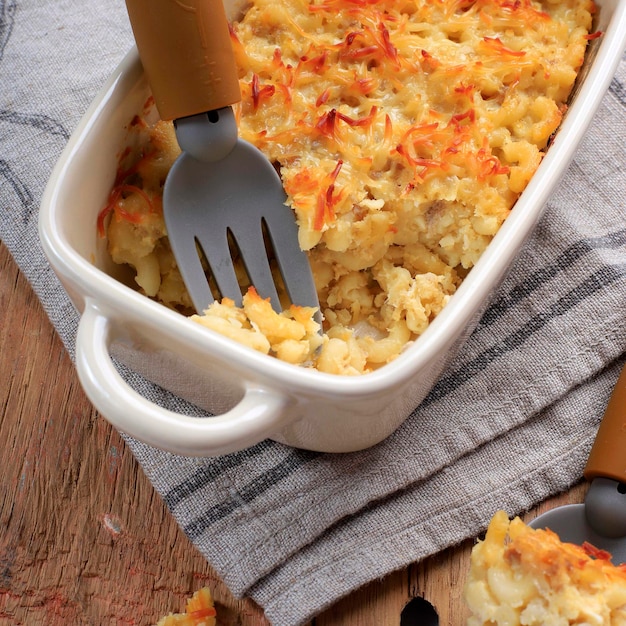 Macarrones con queso caseros para niños. Hecho con macarrones con queso desmenuzado, servido en una fuente para hornear con crema