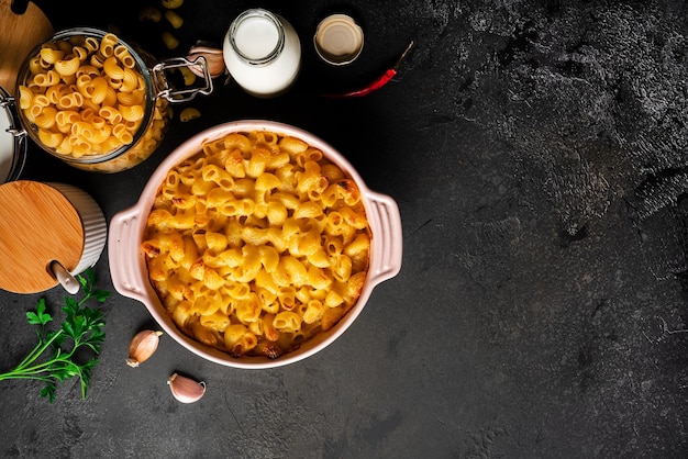 Macarrones con queso, pasta de macarrones al estilo americano en salsa cursi sobre fondo oscuro. Foto de alta calidad