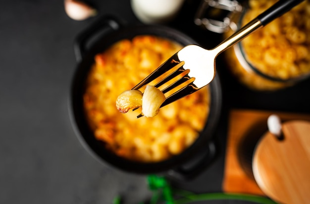 Macarrones con queso, pasta de macarrones al estilo americano en salsa cursi sobre fondo oscuro. Foto de alta calidad