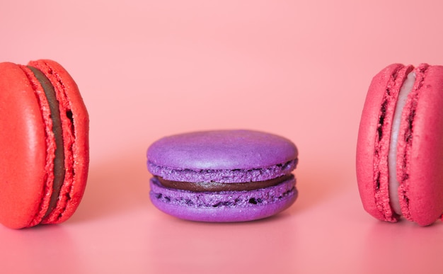 Macarrones rosados y violetas sobre un fondo coral de moda