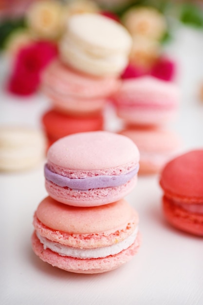 Macarrones con rosas sobre fondo blanco.