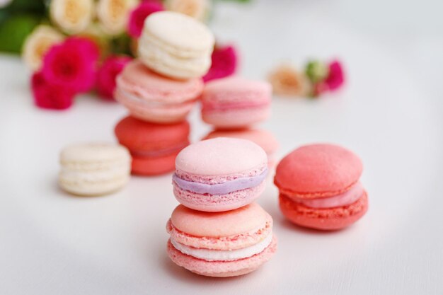 Macarrones con rosas sobre fondo blanco.