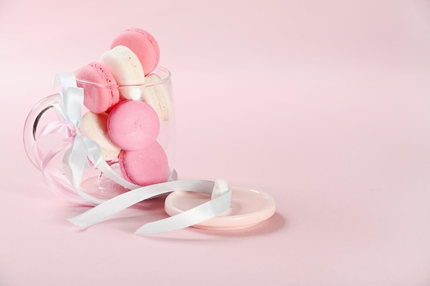 Macarrones rosas en vaso de vidrio sobre un fondo rosa Regalo para el día de San Valentín Ideal para las vacaciones del día internacional de la mujer