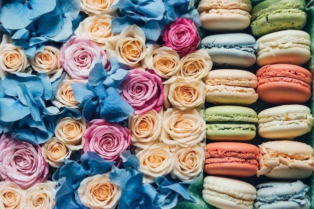 Macarrones surtidos y flores en una caja.