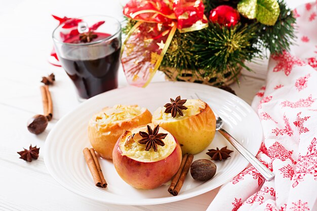 Maçãs assadas recheadas com requeijão, passas e amêndoas para o natal em um branco. sobremesa de comida de natal.