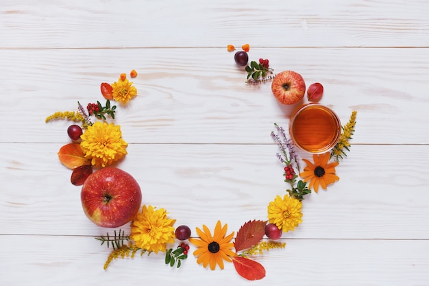 Maçãs, flores e mel com espaço de cópia formam uma decoração floral