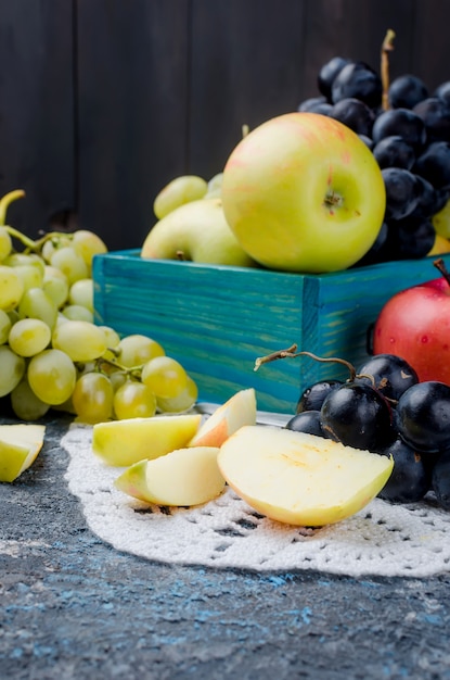 Maçãs frescas colhidas e uvas e frutas pastille em fundo escuro