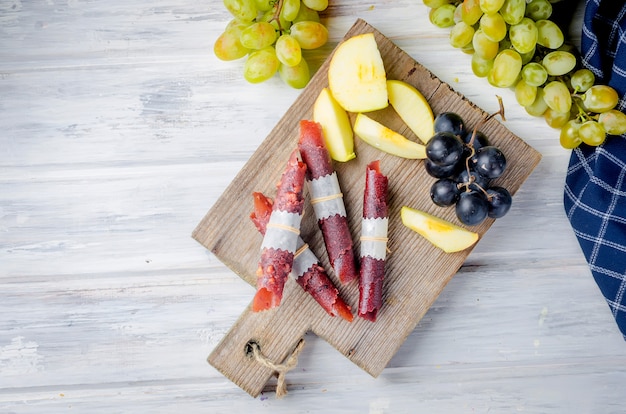 Maçãs frescas colhidas e uvas e frutas pastille em fundo escuro