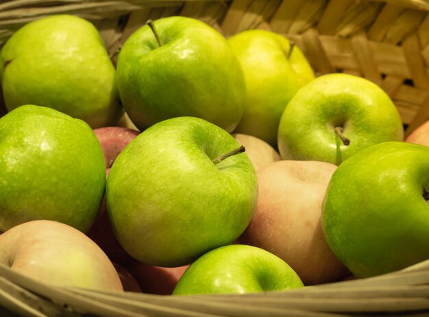 Maçãs orgânicas verdes frescas na cesta pronta para comer.