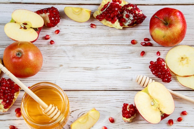 Maçãs romãs e mel em fundo branco de madeira Feliz Rosh Hashanah Símbolos tradicionais da celebração do Ano Novo judaico