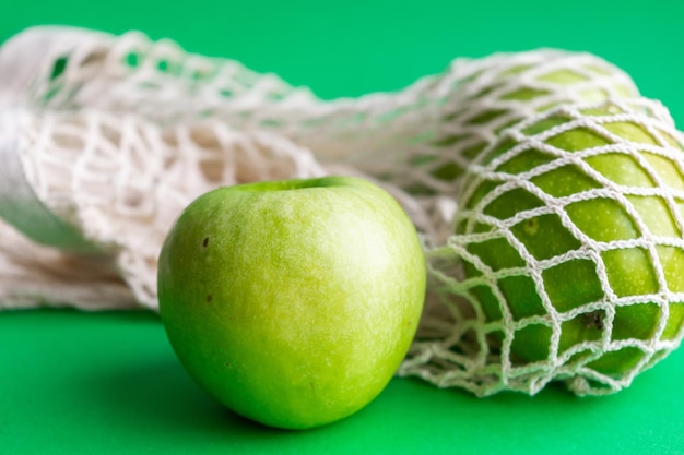 Foto maçãs verdes frescas em um saco de malha alimentos saudáveis embalagens ecológicas reciclagem de resíduos zero desperdício